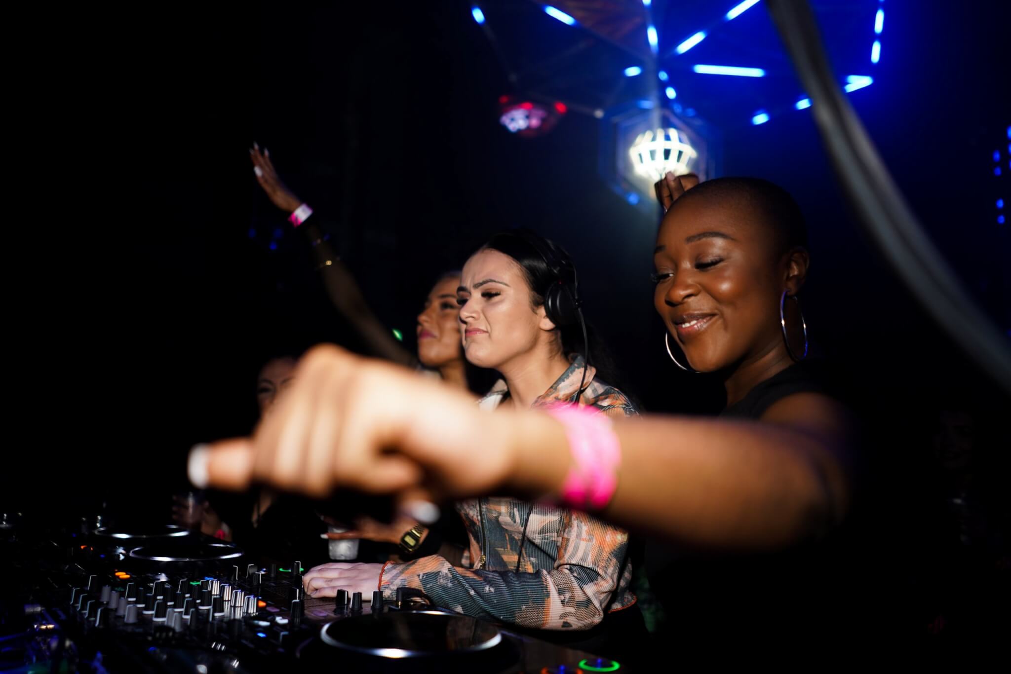 The DJ collective Girls Don't Sync are pictured over a set of decks 