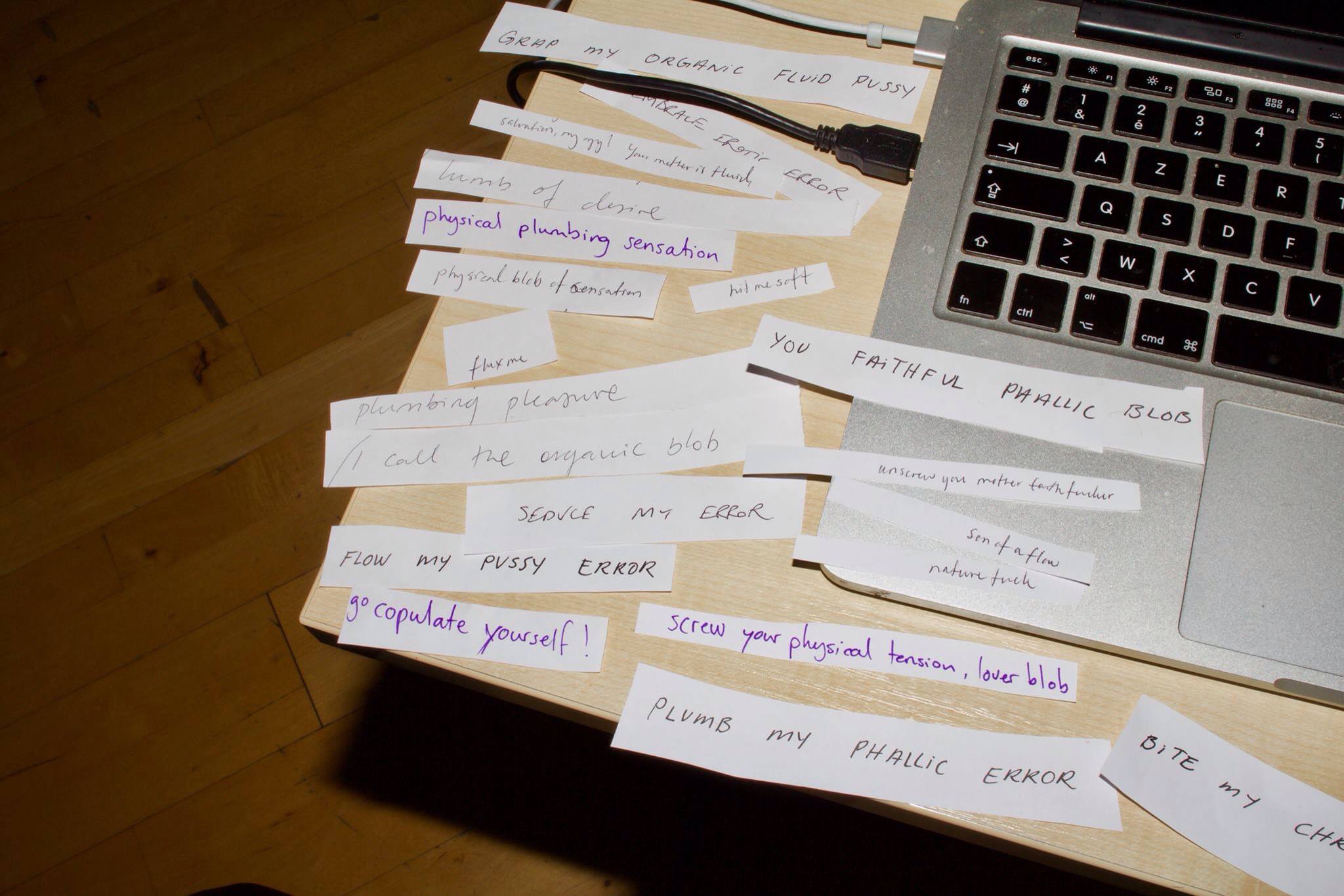 A macbook and table are covered in handwritten lyrics
